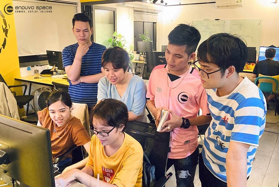 An early Enouvo Space team collaborating around a workstation
